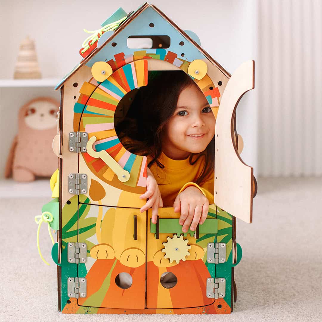 Front view of the large Monyessory wooden busy house, showing vibrant colors and multiple interactive activities.